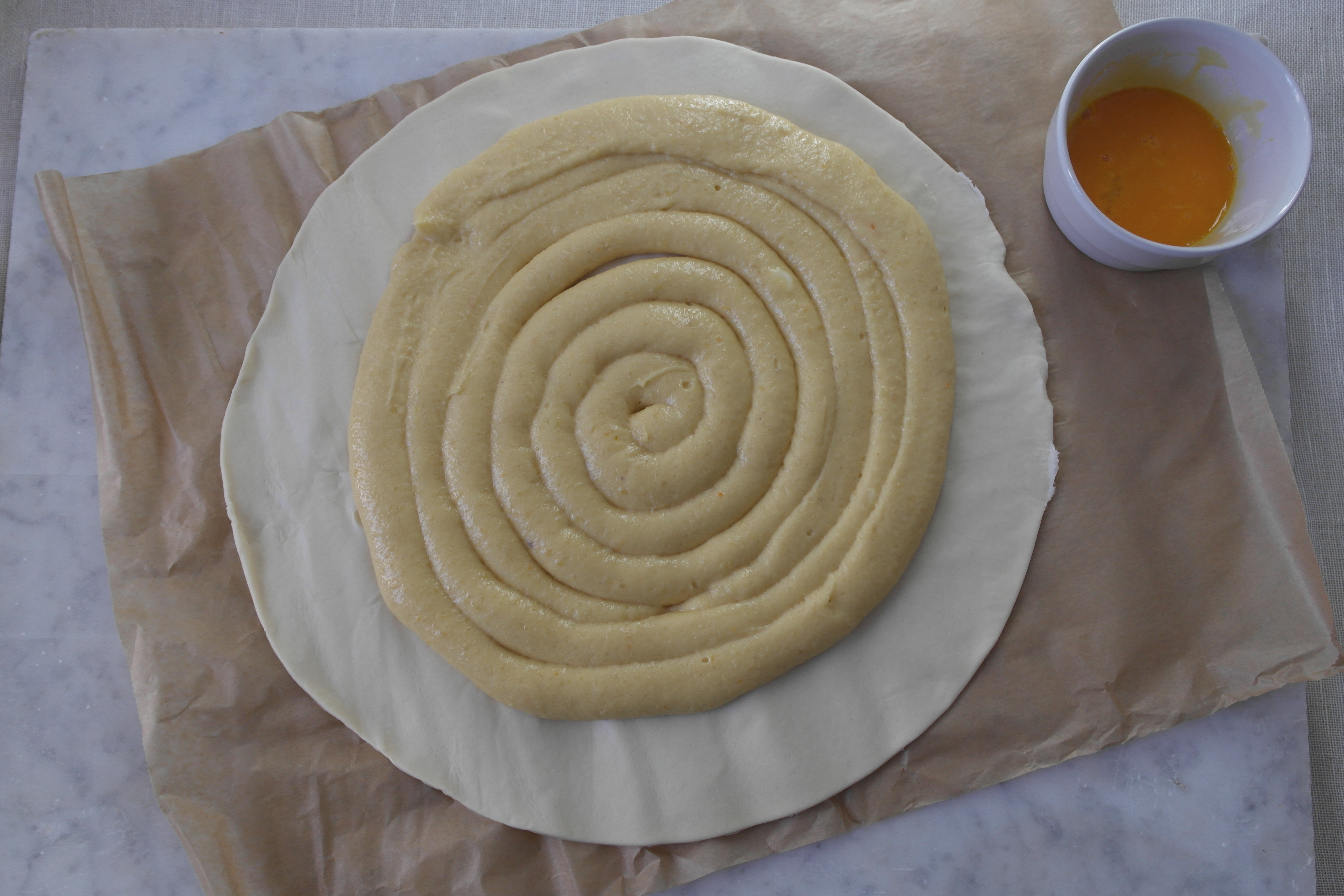 Disposez la crème sur la pâte feuilletée puis dorer au jaune d'oeuf