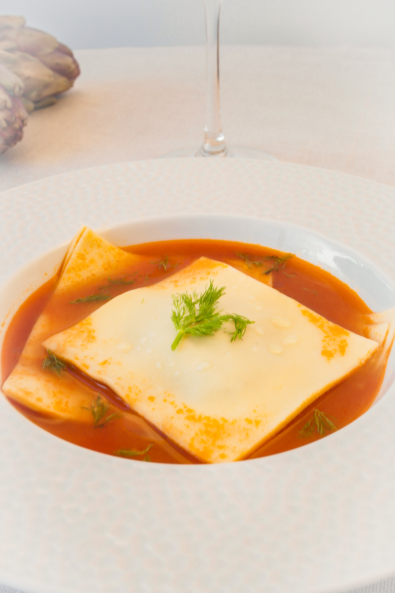 Ravioles d'artichaut et de crevettes accompagnées d'une bisque