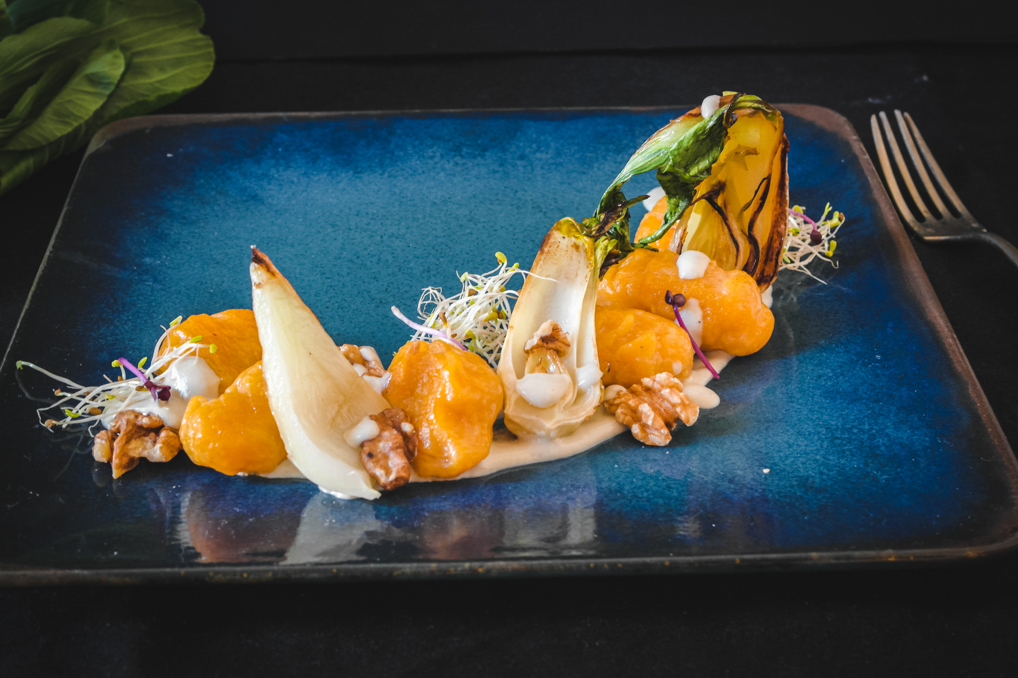 Photo d'une assiette bleu avec les gnocchis au butternut, le boy choy, noix et la sauce à la fourme d'ambert